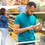 focused-african-american-man-reading-information-packaging-1-scaled
